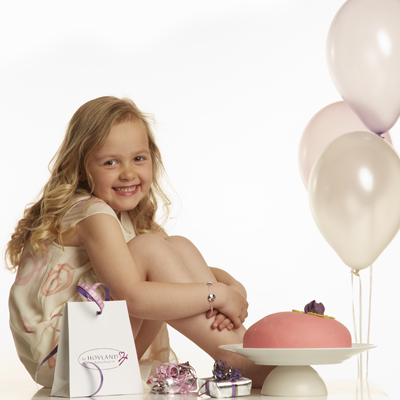 Kalas tjej med tårta och ballonger med barnhalsband och barnarmband