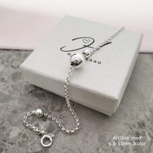 Silversmycke med kulor i olika storlekar på en kedja.