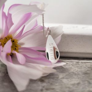 Handgjort namnsmycke med formen av en droppe i silver